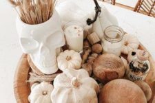 a simple fall to Halloween decoration fo a wooden bowl with wooden beams, gourds, candles, a skull vase with bunny tails is gerat