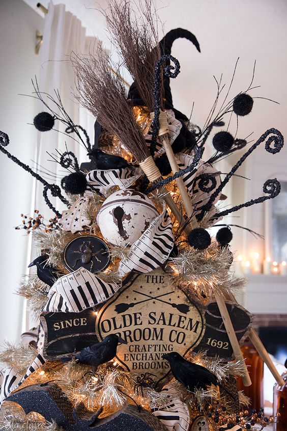 a vintage Halloween tree in black and white, with vintage signs, bells, brooms and a witch's hat plus some blackbirds is cool