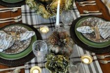 a vintage Thanksgiving tablescape with a plaid runner, green and floral plates, quote napkins,a gold pumpkin and candleholders