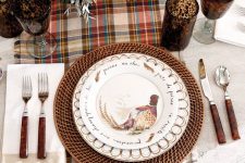 a vintage rustic Thanksgiving tablescape with a plaid runner, woven chargers, printed plates, vintage cutlery and bold blooms and glasses