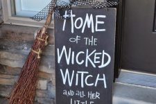 easy front porch Halloween styling with a pumpkin, a chalkboard sign, a broom and witches’ shoes