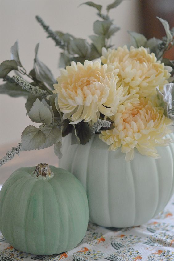 light green pumpkins, pale greenery and white blooms make up cool rustic decor for Thanksgiving