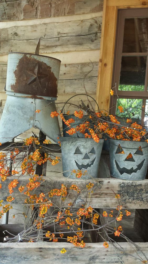 metal buckets with scary faces and lots of branches with berries for easy rustic Halloween decor