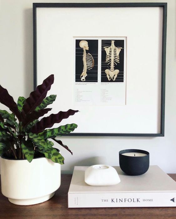minimalist Halloween decor with a skeleton artwork and a candle in a black jar is a lovely and simple idea