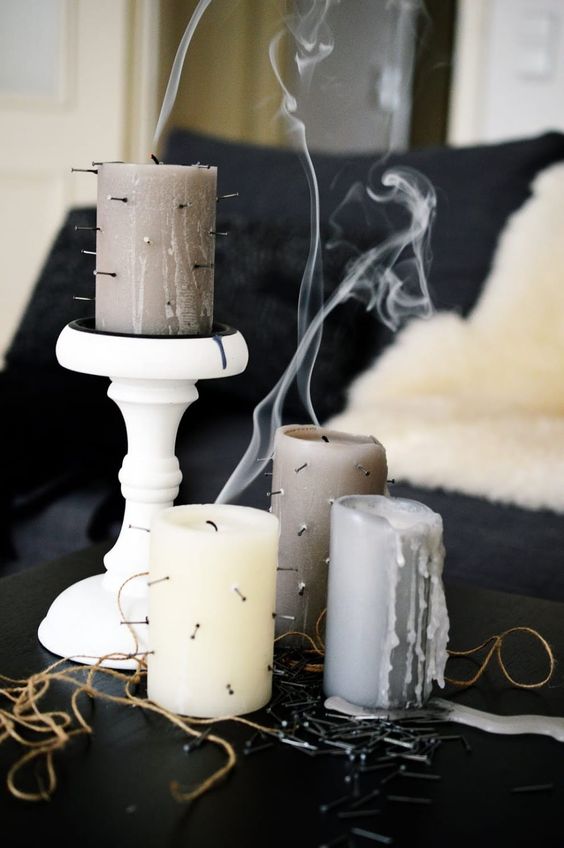 minimalist grey and neutral candles decorated with nails are all you need for minimal Halloween decor