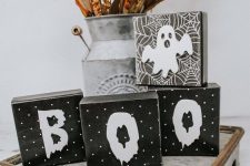 rustic Halloween styling with wooden cube letters, a ghost, a bright dried arrangement in a metal churn