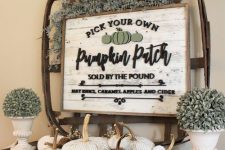 rustic Thanksgiving decor with greenery, a basket with a sign, white and rust colored pumpkins feels vintage and chic