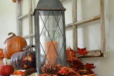 rustic vintage Thanksgiving decor of bright leaves, pinecones, pumpkins and dried leaves and berries over the table