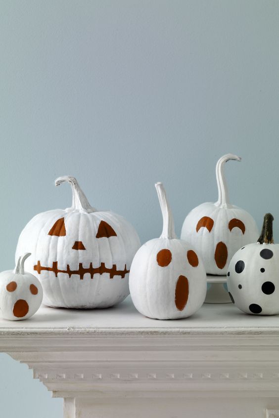 white pumpkins with faces painted isntead of carving is a great and fast DIY you can easily realize