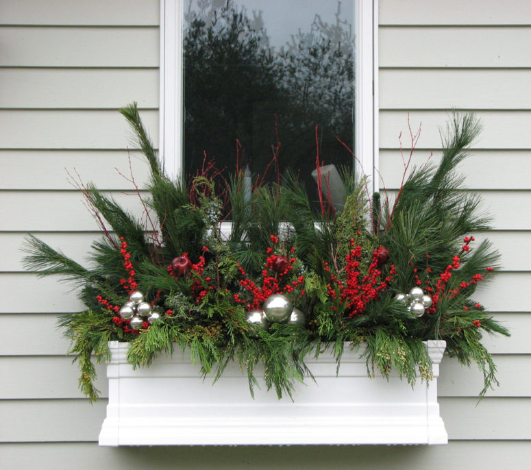 Fill a flower box with holiday decorations like evergreen twigs, berries and ornaments.