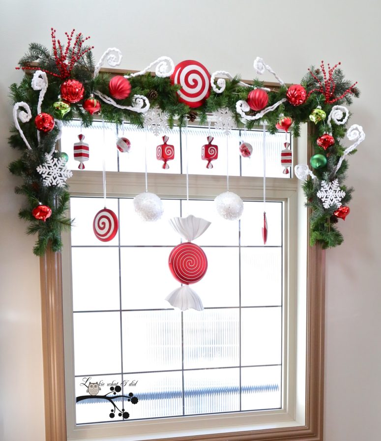 Faux candies in red-white tones would become a great addition to an evergreen swag topping the window.