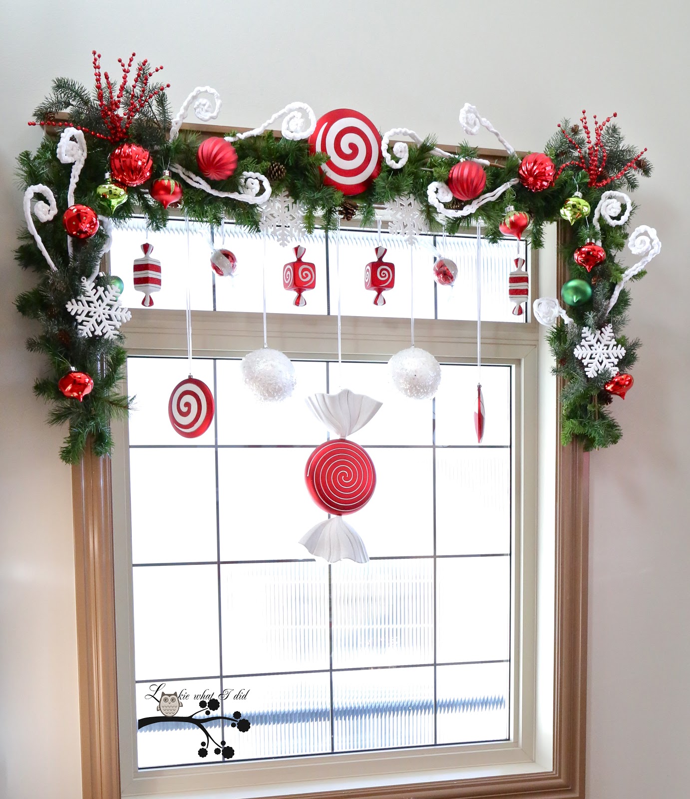 Faux candies in red-white tones would become a great addition to an evergreen swag topping the window.