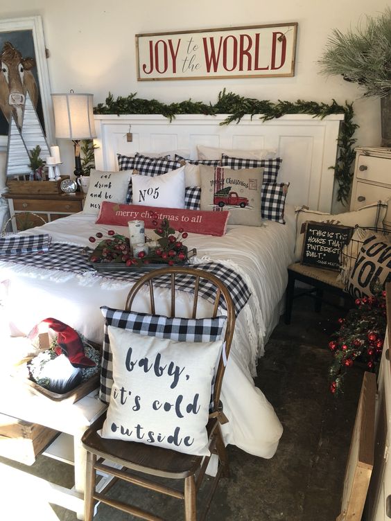 a Christmas bedroom with plaid bedding, evergreens and pinecones, berries and branches for a more natural feel