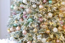 a Christmas tree decorated with blush, pastel pink, green, gold glitter ornaments and lights is a beautiful solution with a soft feel