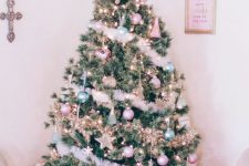 a Christmas tree decorated with pastel green and pink ornaments, stars, lights and fluffy garlands plus a star topper