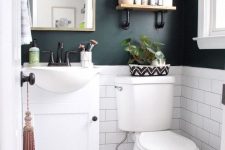 a black and white powder room with black walls, white subway tiles, Moroccan tiles on the floor, a white vanity and white appliances