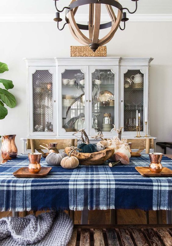 a blue plaid tablecloth and some blue fabric pumpkins make the tablescape more modern and bold