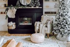 a boho farmhouse Christmas living room with a flocked tree and a cluster of such mini trees on the mantel plus stockings