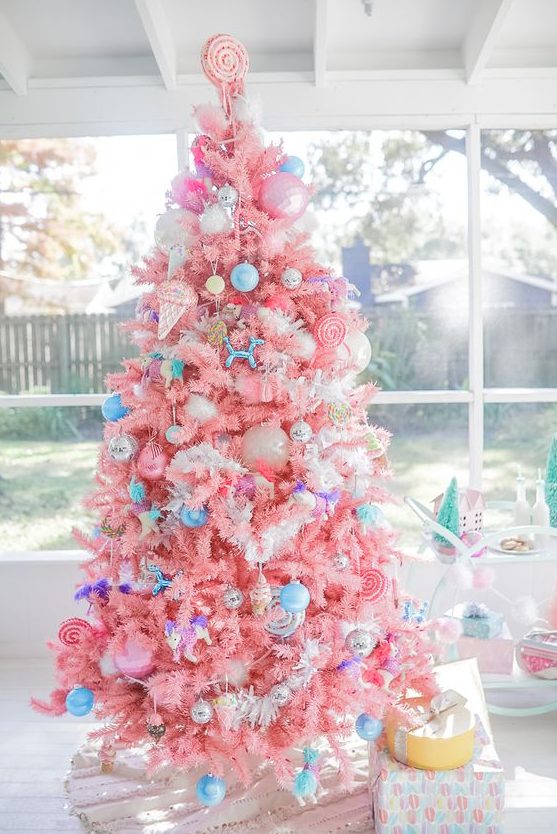 A bright candy colored Christmas tree with bold blue ornaments, ice cream and popsicle ornaments and a candy topper