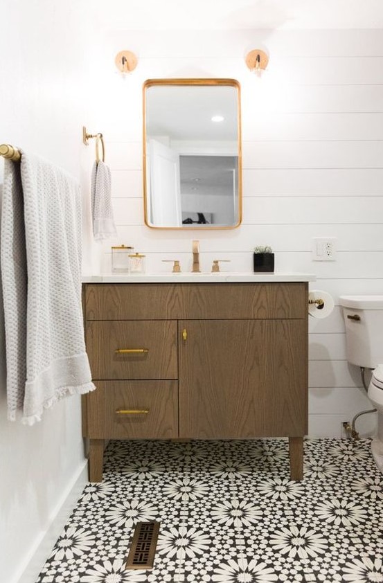 a chic bathroom with white plank walls, a Moroccan tile floor, a stained vanity, gold fixtures and neutral textiles is a lovely space