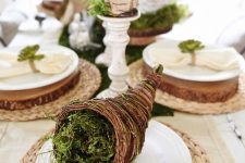 a cornucopia with moss, brich bark wrapped candles on vintage stands for a natural feel at the table