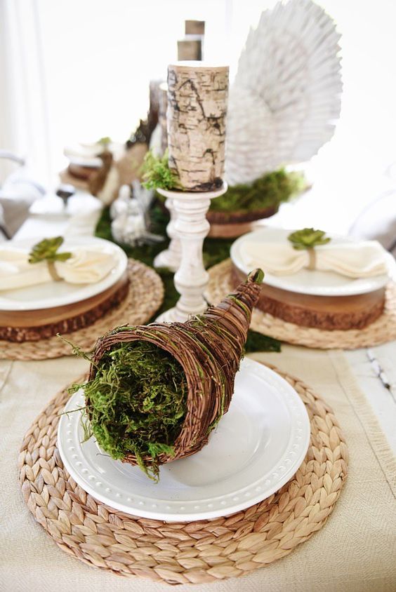 a cornucopia with moss, brich bark wrapped candles on vintage stands for a natural feel at the table