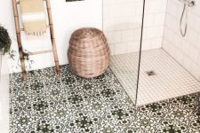 a cozy bathroom clad with white subway and smaller scale tiles, with green Moroccan tiles, a bamboo ladder, a basket for storage is cool