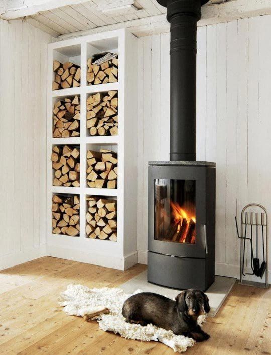 a fireplace and an open storage unit by its side make up a very cozy and chic nook and add warmth to the space