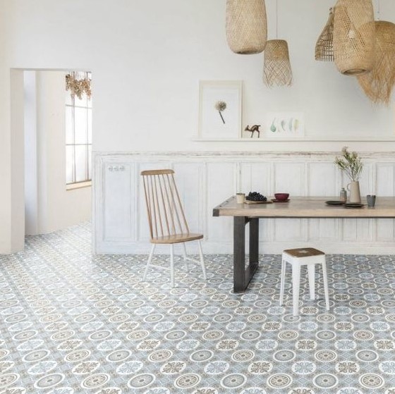 A laid back dining room with white panels on the walls, a Moroccan tile floor, a dining table, cool chairs and woven pendant lamps