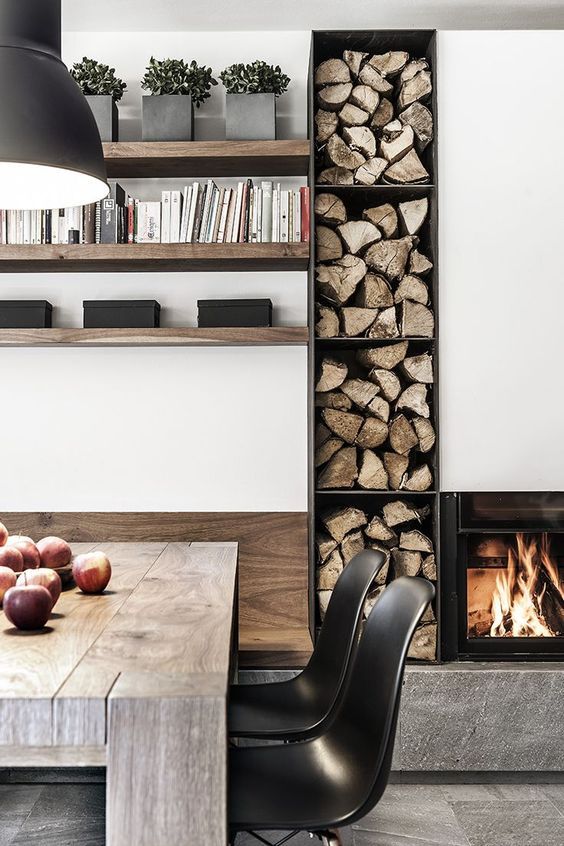 A minimalist built in fireplace and an open storage unit with firewood for warming and cozying up a minimalist space