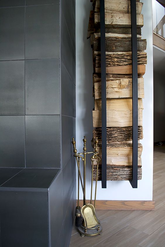A modern and laconic wall mounted firewood holder is a very stylish idea for a minimalist space and looks cool and chic