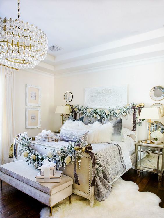 a neutral Christmas bedroom with pale greenery garlands with ornaments, gift boxes, white blooms for a refined and chic look