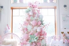 a neutral Christmas tree decorated with pink and pastel green ornaments, candy canes, faux blooms and cupcakes is amazing