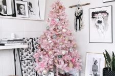 a pastel pink Christmas tree decorated with striped black and white, blush, gold glitter and brown ornaments is a lovely idea for any space
