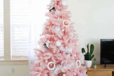 a pastel pink Christmas tree with skate and donut ornaments, pompoms and a shiny snowflake tree topper is amazing