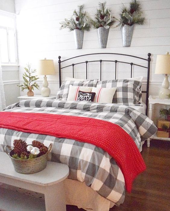 a red knit blanket, plaid bedding, snowy evergreens, pinecones and ornamnts for a warming up and cozy feeling in the bedroom