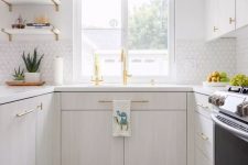 a serene kitchen with whitewashed cabinets, white tiles on the backsplash, colorful Moroccan tiles and gold fixtures