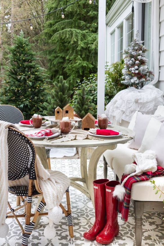 a simple and lovely Christmas tablescape with red and plaid napkins, wooden houses and hot chocolate welcomes