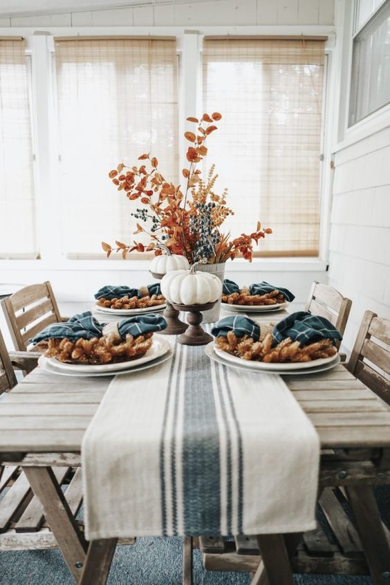 a simple and rustic tablescape done with teal plaid napkins and a striped runner that contrast the earthy tones here