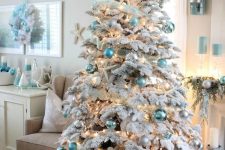 a sophisticated flocked Christmas tree with mint, aqua, silver, white ornaments, ribbons, lights, starfish is very chic