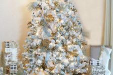 a super glam pastel blue Christmas tree with velvet ribbon, lots of lights and gold touches for a bright and shiny look