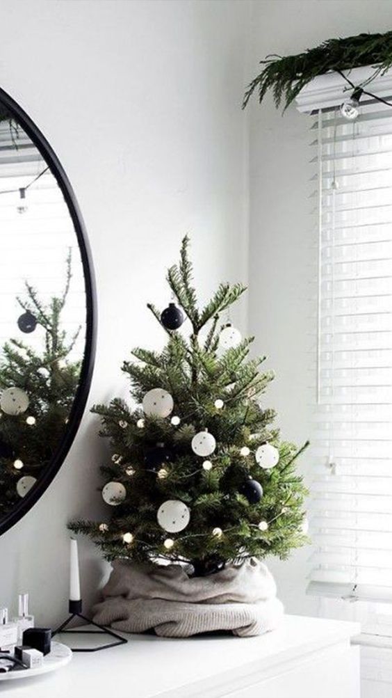 a tabletop Christmas tree with lights and black and white ornaments is a perfect monochromatic piece