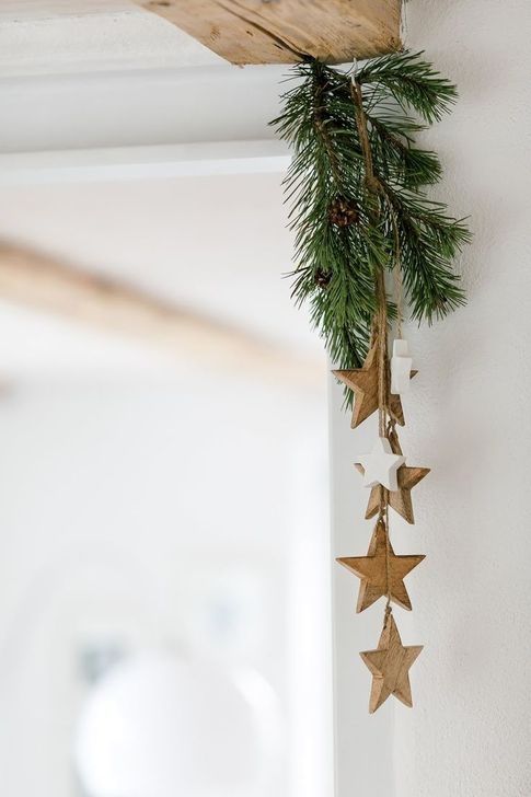 An evergreen and wooden star posie attached to the corner is a stylish all naturla idea to go for