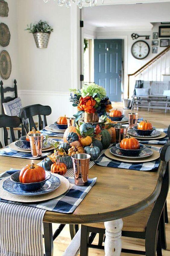 blue and white plaid placemats, blue and orange pumpkins, blue flwoers and striped napkins for Thanksgiving