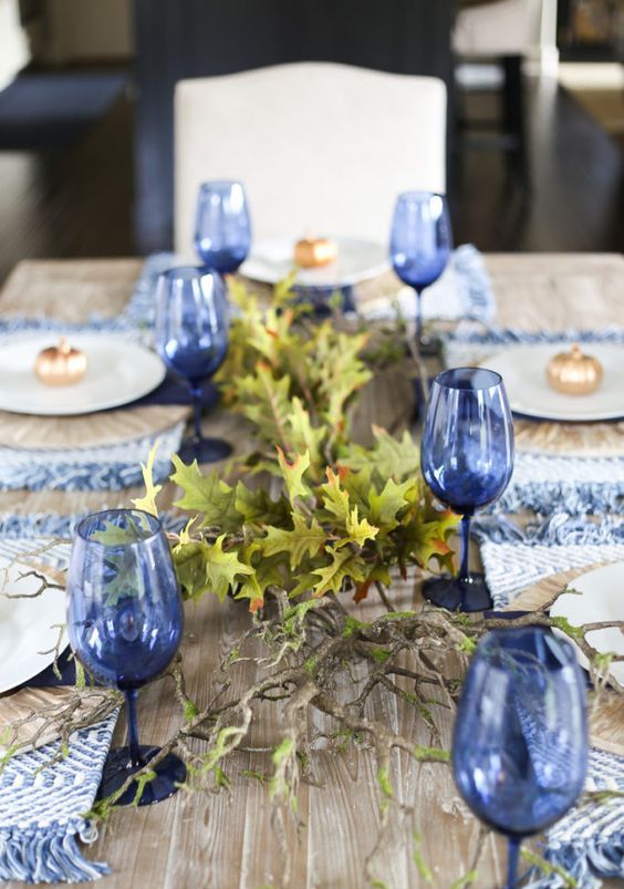 blue woven placemats with fringe and blue glasses will give a new and frehs look to your Thanksgiving table