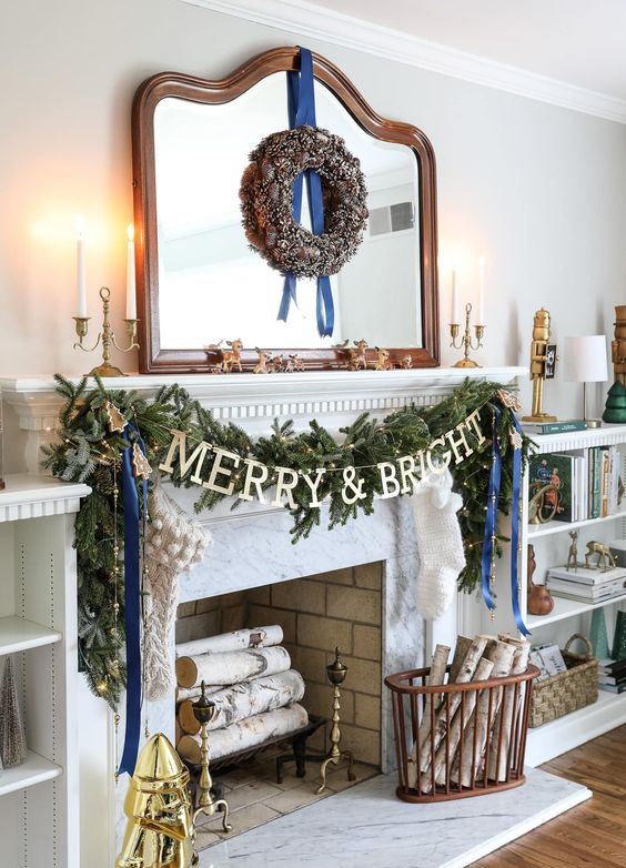 chic Christmas decor with a pinecone wreath, a fir garland with lights and blue ribbons, branches in a basket