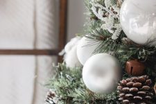 decorate your Christmas tree with pinecones, cotton, bells and white ornaments to give it a cozy rustic look
