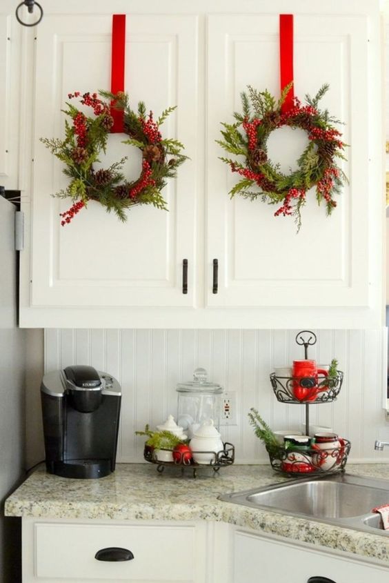 evergreen Christmas wreaths with pinecones and berries plus red ribbons for a holiday feel in the space
