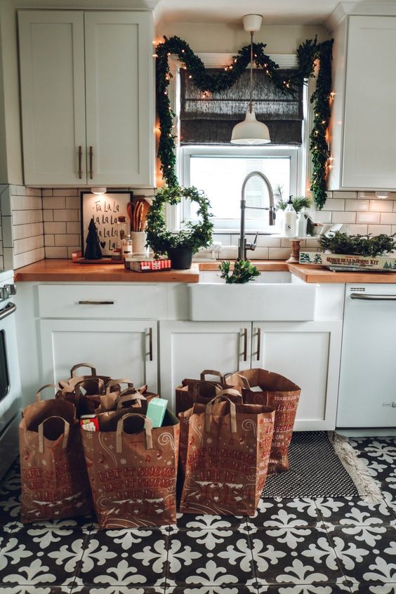evergreen garlands with lights, a round wreath and candles for a cool and cute farmhouse Christmas kitchen