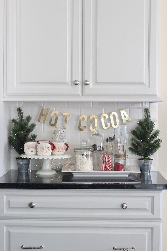 mini Christmas trees with lights, Santa mugs, sweets and gold letters for a cool and cute Christmas nook